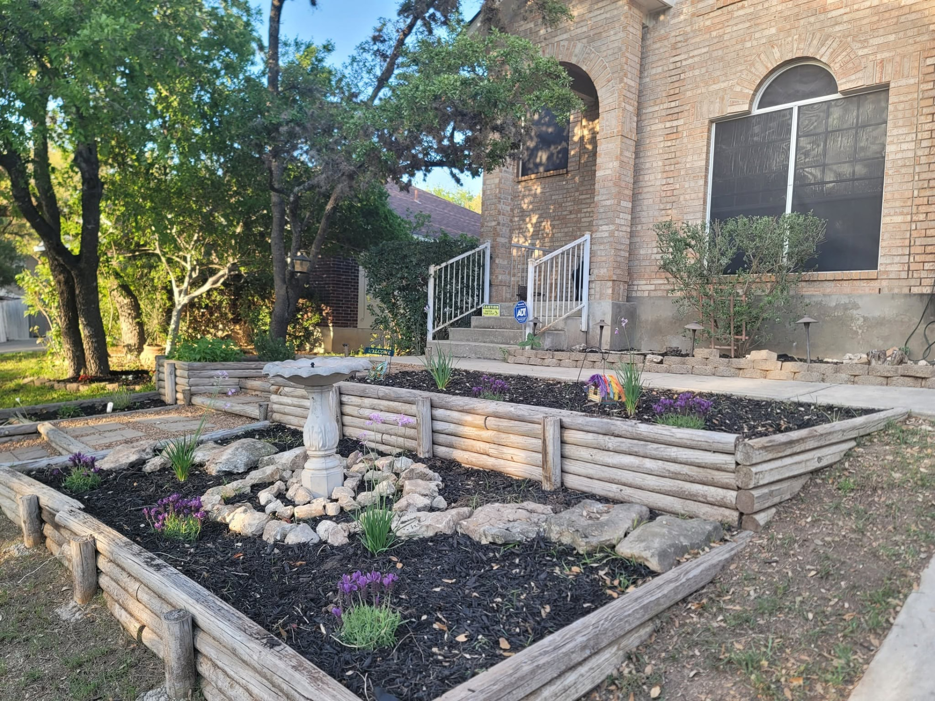 Front yard flower beds with fresh mulch and stonework